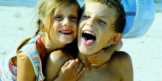 Two laughing children at the beach